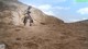 A woman standing on top of a dirt hill.