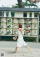 A woman in a white dress is walking in front of a shrine.