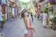 A woman wearing a face mask walking down a street.