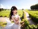 A woman in a white dress standing on a dirt road.