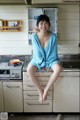 A woman sitting on top of a kitchen counter.