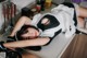 A woman laying on top of a kitchen counter next to a stove.