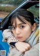 A young girl sitting in the passenger seat of a car.