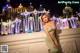 A woman in a green dress posing in front of a fountain.