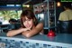 A woman leaning on a counter in a restaurant.