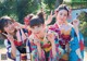 A group of three young women in kimonos posing for a picture.